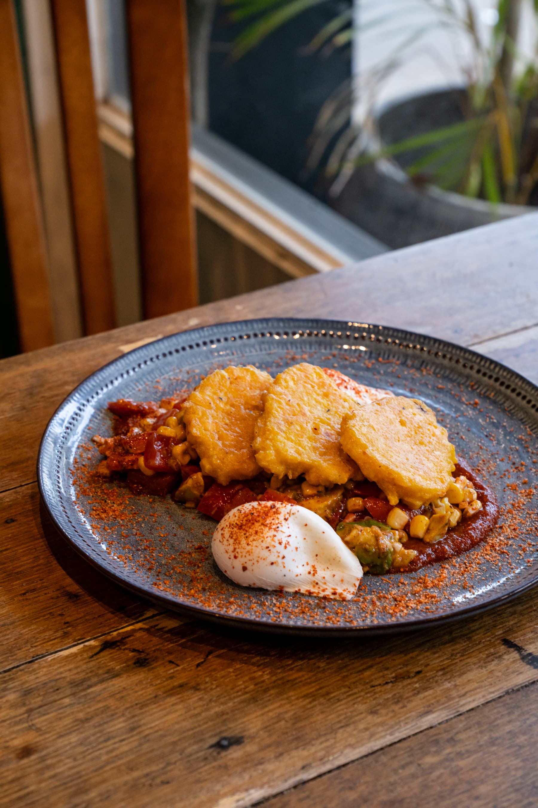 Breakfast plate with corn fritters, salsa and poached egg