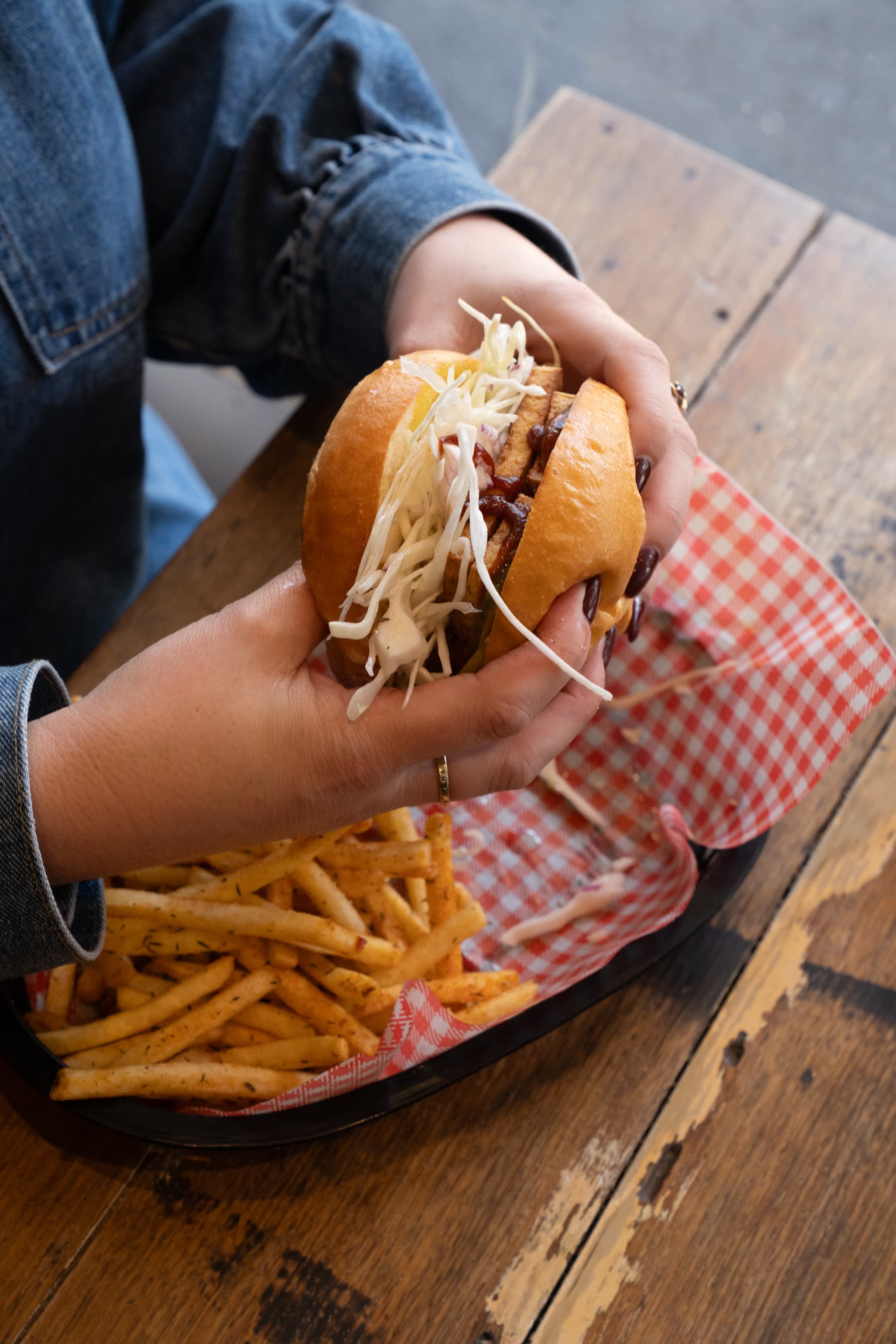 Close-up of a burger with chips on a timber table