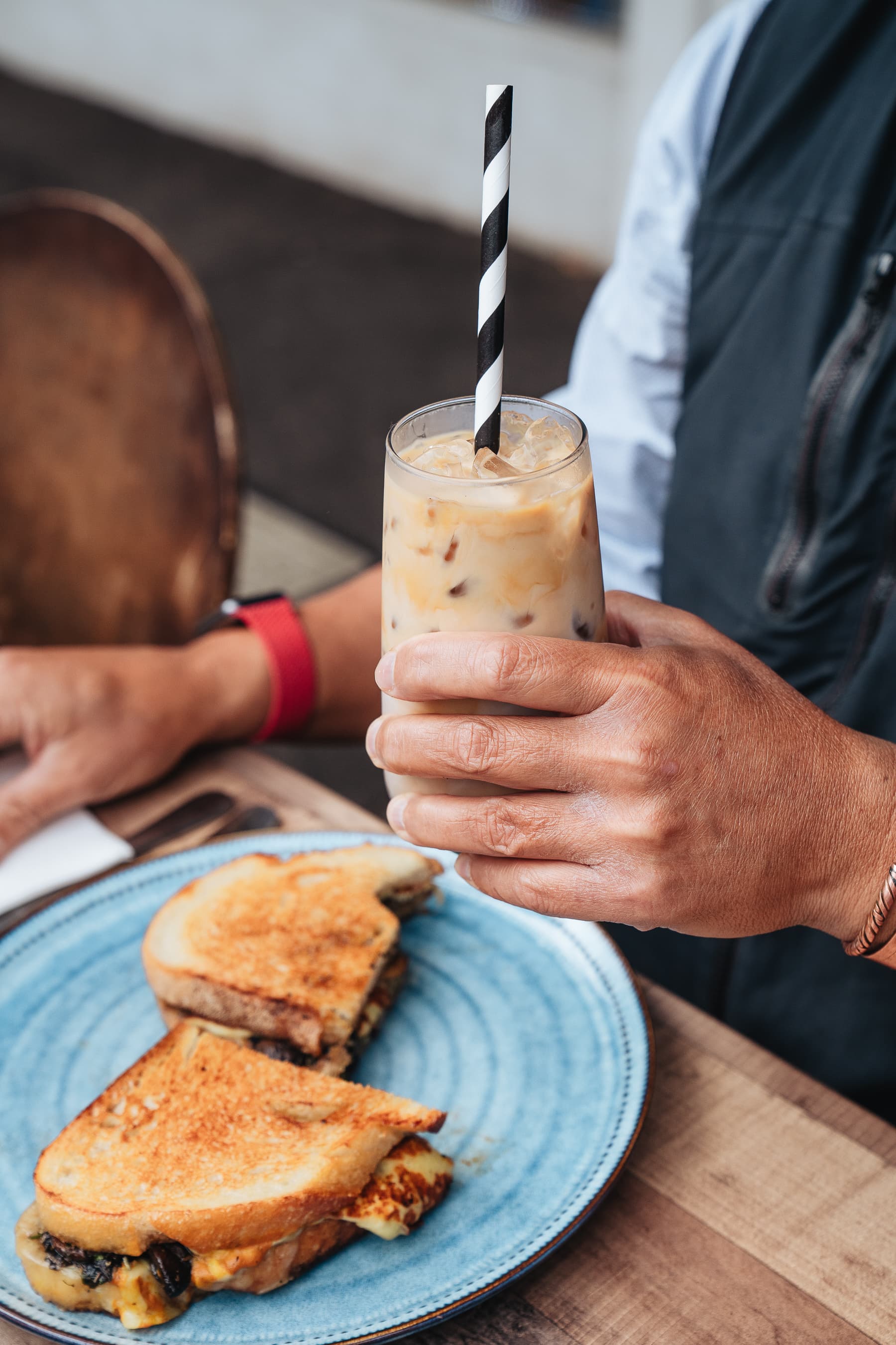 Iced coffee and toasted sandwich served on a blue plate