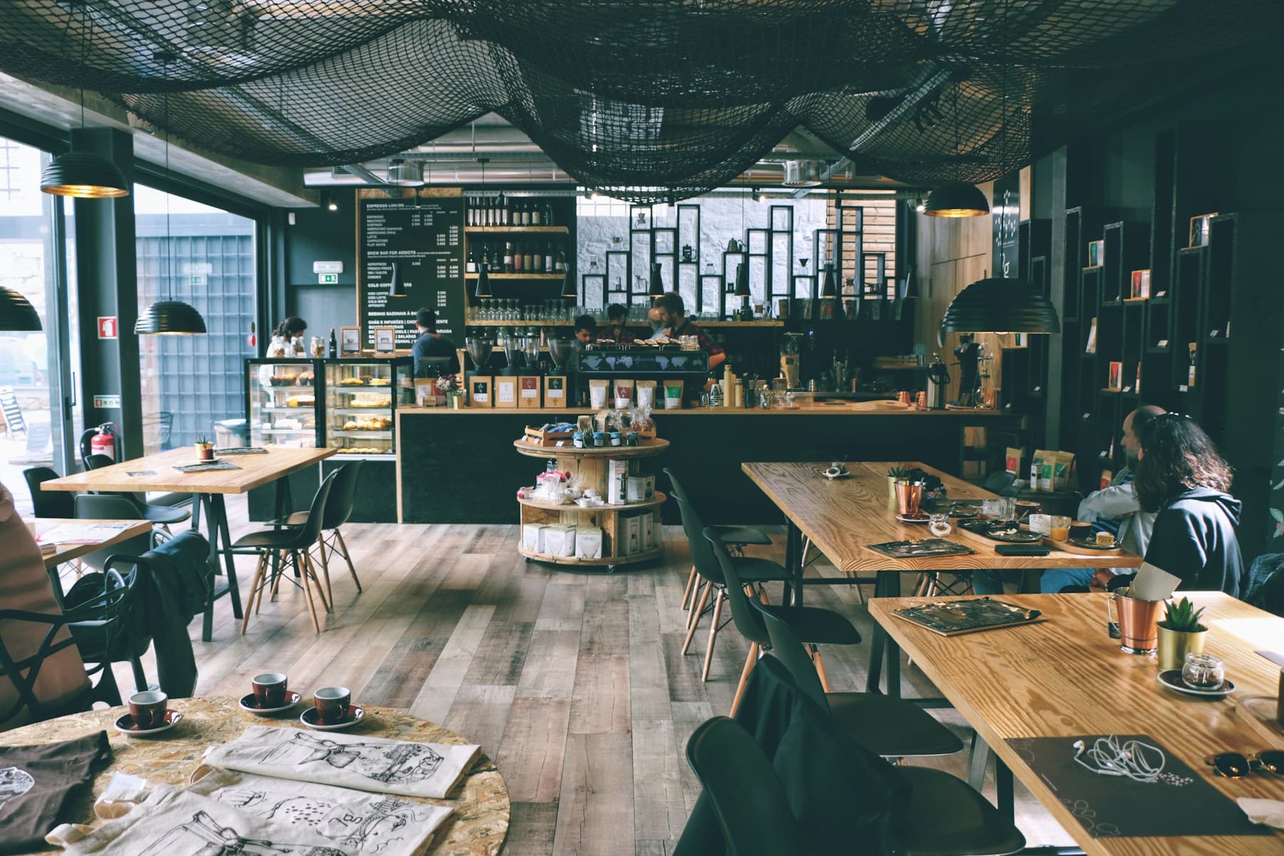 Warm modern cafe interior with dark walls and timber seating